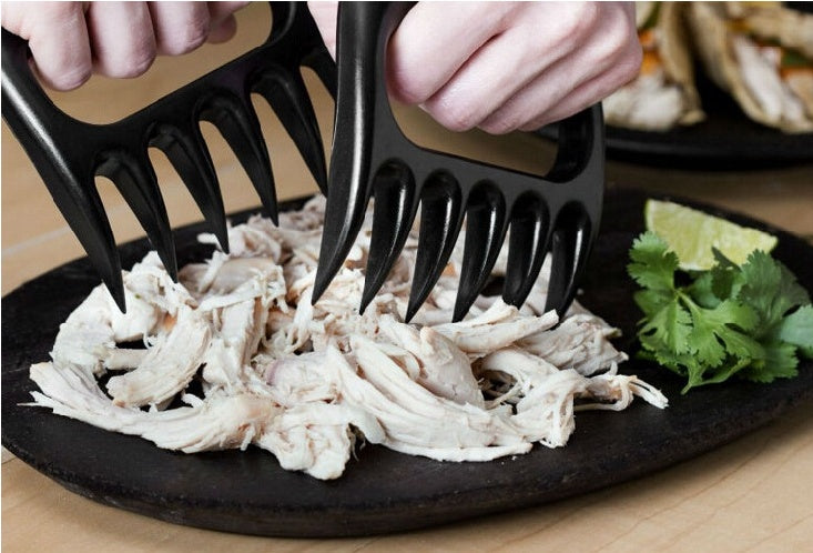 Bear claw meat shredders being used to shred slow-cooked BBQ pork shoulder