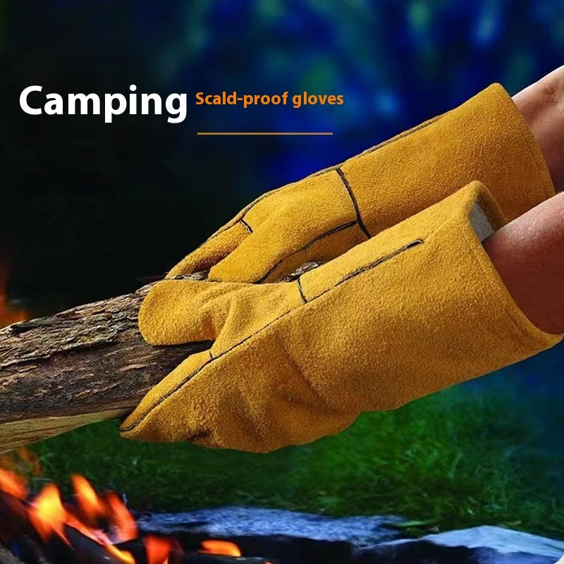 Yellow camping scald-proof gloves holding a branch over a campfire with a blurred natural background.